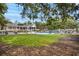 Beautiful community pool area surrounded by green lawn, lounge chairs, and screened-in buildings for relaxing at 3034 Oak Grove Bend # 34 Ar, Murrells Inlet, SC 29576