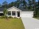 Inviting one-story home featuring a two-car garage, neutral siding, and a well-manicured lawn at 9727 Indigo Creek Blvd., Murrells Inlet, SC 29576