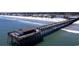 Aerial view of a large pier extending into the ocean, complete with a covered structure at the end at 9727 Indigo Creek Blvd., Murrells Inlet, SC 29576