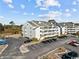 Aerial view of a three-story building with surrounding parking and landscape at 1100 Possum Trot Rd. # F-215, North Myrtle Beach, SC 29582