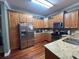 A contemporary kitchen with stainless steel refrigerator, granite countertops, and wooden cabinets at 2347 Devine St., Georgetown, SC 29440