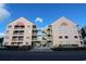 Front view of a two-story pink building with two staircases at 2710 S Ocean Blvd. # 208, Myrtle Beach, SC 29577