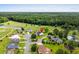 High angle aerial view of neighborhood home, golf course, ponds, mature trees, and wooded backdrop at 428 Meadow View Ct., Longs, SC 29568