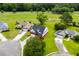 Aerial view of a neighborhood home, manicured lawn, mature trees, and golf course in background at 428 Meadow View Ct., Longs, SC 29568
