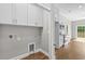 Laundry room with modern wood-look flooring and white cabinets at 428 Meadow View Ct., Longs, SC 29568