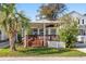 Charming single-story home featuring a large front porch, well-kept lawn, and a mature palm tree at 6001-S32 S Kings Hwy., Myrtle Beach, SC 29575