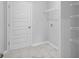 Simple laundry room with marble style tile floor, shelving and a white painted door at 9742 Indigo Creek Blvd., Murrells Inlet, SC 29576