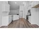 Bright, modern kitchen featuring white cabinets, stainless steel appliances, and hardwood floors at 9746 Indigo Creek Blvd., Murrells Inlet, SC 29576