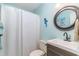 Compact bathroom with a round mirror and light blue walls at 603 Bucks Trail, Longs, SC 29568