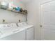 Well-lit laundry room includes a washer, dryer, storage shelf and a door at 603 Bucks Trail, Longs, SC 29568