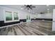 A spacious living room features luxury vinyl plank flooring, paneled accent walls, three windows, two ceiling fans, and recessed lights at 1010 Club House Dr., North Myrtle Beach, SC 29582