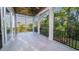 An outdoor screened in porch with wood ceiling, tile floor, black aluminum railing, and views of trees and a building at 1010 Club House Dr., North Myrtle Beach, SC 29582