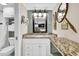 Bathroom vanity with granite countertop, decorative wall art, and soft lighting at 2001 S Ocean Blvd. # 1506, Myrtle Beach, SC 29577