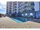 Outdoor pool area with lounge chairs and a view of the condo building at 2001 S Ocean Blvd. # 1506, Myrtle Beach, SC 29577