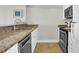 Kitchen features white cabinets, granite countertops, stainless steel dishwasher and ceramic tile floors at 2001 S Ocean Blvd. # 905, Myrtle Beach, SC 29577