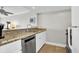 Galley kitchen features white cabinets, granite countertops, stainless steel dishwasher and ceramic tile floors at 2001 S Ocean Blvd. # 905, Myrtle Beach, SC 29577