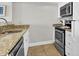 The kitchen features white cabinets, stainless steel appliances, granite countertops, and ceramic tile floors at 2001 S Ocean Blvd. # 905, Myrtle Beach, SC 29577