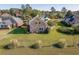 Aerial view of a stone-clad home with a well-manicured lawn and beautiful landscaping at 565 Bucks Trail, Longs, SC 29568