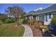Charming home featuring a stone walkway, lush landscaping, and a birdbath in the front yard at 565 Bucks Trail, Longs, SC 29568