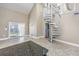 Open living area with wet bar and spiral staircase, illuminated by natural light from large windows at 565 Bucks Trail, Longs, SC 29568