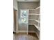 Bright pantry with built-in white shelving and natural light from a window at 1006 Cuttino St., Georgetown, SC 29440
