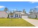 Inviting single-story home with a manicured lawn, stone accents, blue siding, and a two-car garage at 131 Grissett Lake Dr., Conway, SC 29526
