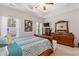 Bright main bedroom with a large bed, dresser, and mirror, illuminated by natural light at 131 Grissett Lake Dr., Conway, SC 29526