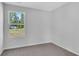 Bright bedroom with gray carpet and light gray walls and window looking out to trees and a street at 1526 Clubstone Dr., Conway, SC 29526