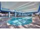 Well-lit indoor pool with a brick pool deck and multiple tables and chairs at 2311 S Ocean Blvd. # 438, Myrtle Beach, SC 29577