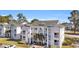Three story condo with white balconies and pillars and palm trees in front at 556 White River Dr. # 44F, Myrtle Beach, SC 29579