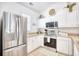 Well-lit kitchen showcases stainless steel refrigerator and stove along with white cabinets and light countertops at 601 Hillside Dr. N # 4133, North Myrtle Beach, SC 29582