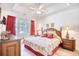 Bright primary bedroom boasts tray ceiling, wood furniture, and a large window dressed with red curtains at 601 Hillside Dr. N # 4133, North Myrtle Beach, SC 29582
