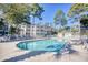 Inviting community pool surrounded by trees and condo buildings at 601 Hillside Dr. N # 4133, North Myrtle Beach, SC 29582