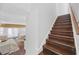 Wooden staircase adjoins dining and living rooms with bright, neutral decor at 656 Pistoia Ln. # 304, Myrtle Beach, SC 29579