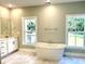 Elegant bathroom with a freestanding tub and views from the windows and white marble floors at 909 Grimes St., Georgetown, SC 29440