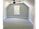 A bright bedroom features a ceiling fan, gray walls, white trim, and a window letting in natural light at 909 Grimes St., Georgetown, SC 29440