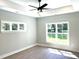 Light-filled bedroom with tray ceiling, modern ceiling fan, and large windows overlooking the lawn at 909 Grimes St., Georgetown, SC 29440
