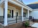 Beautiful front porch features wood ceiling, white columns and black railings for modern curb appeal at 909 Grimes St., Georgetown, SC 29440