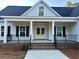Inviting front porch with brick stairs, black railings, and a stylish wood ceiling at 909 Grimes St., Georgetown, SC 29440
