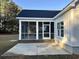Rear exterior featuring a screened-in porch with brick skirting, a concrete patio, and a freshly seeded lawn at 909 Grimes St., Georgetown, SC 29440