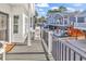 Deck with white chairs and welcome mat, overlooking houses and street at 6001 - 1778 S Kings Hwy., Myrtle Beach, SC 29575