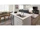 Modern kitchen island with stainless steel sink, dishwasher, and white cabinets next to dining and living area at 1083 Oak Meadow Dr., Conway, SC 29526