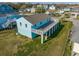 Rear view of light blue house, elevated deck, grassy yard at 243 Calhoun Dr., Garden City Beach, SC 29576
