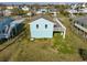 Rear view of beach house, showcasing elevated deck and yard at 243 Calhoun Dr., Garden City Beach, SC 29576