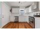 Updated kitchen with white cabinets, stainless steel appliances, and hardwood floors at 243 Calhoun Dr., Garden City Beach, SC 29576