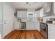 Updated kitchen with white cabinets, stainless steel appliances, and hardwood floors at 243 Calhoun Dr., Garden City Beach, SC 29576