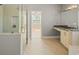 This bright bathroom features a glass shower, a double vanity, and a door to the primary bedroom at 302A 32Nd Ave. N, North Myrtle Beach, SC 29582