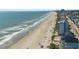 A scenic aerial view of the beach, highlighting the ocean, sandy shore, and nearby buildings at 302A 32Nd Ave. N, North Myrtle Beach, SC 29582