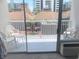 View from condo balcony includes white chairs and table with views of neighboring building at 6803 N Ocean Blvd. # 210, Myrtle Beach, SC 29572