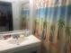 Bright bathroom with a patterned shower curtain and white vanity with ample mirror space at 6803 N Ocean Blvd. # 210, Myrtle Beach, SC 29572